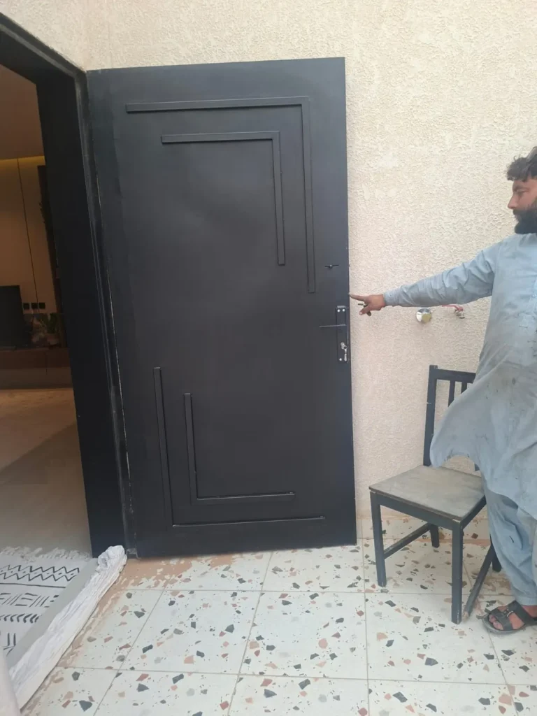باب حديد أسود بزخرفة خطوط بارزة على شكل زوايا