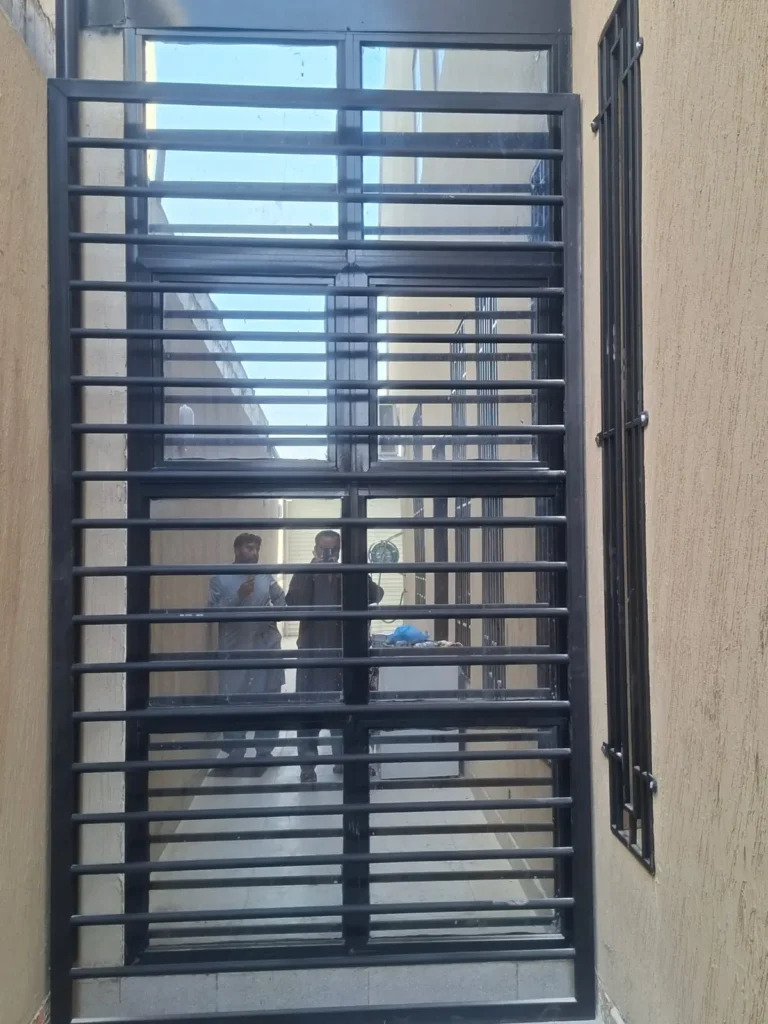 شبك حماية حديد بقضبان أفقية على نافذة طويلة