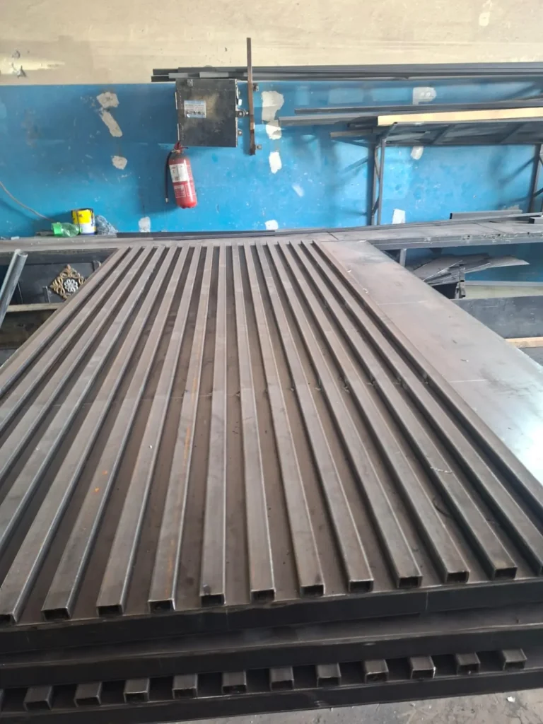 هيكل باب حديد بمربعات طولية أثناء التصنيع في الورشة